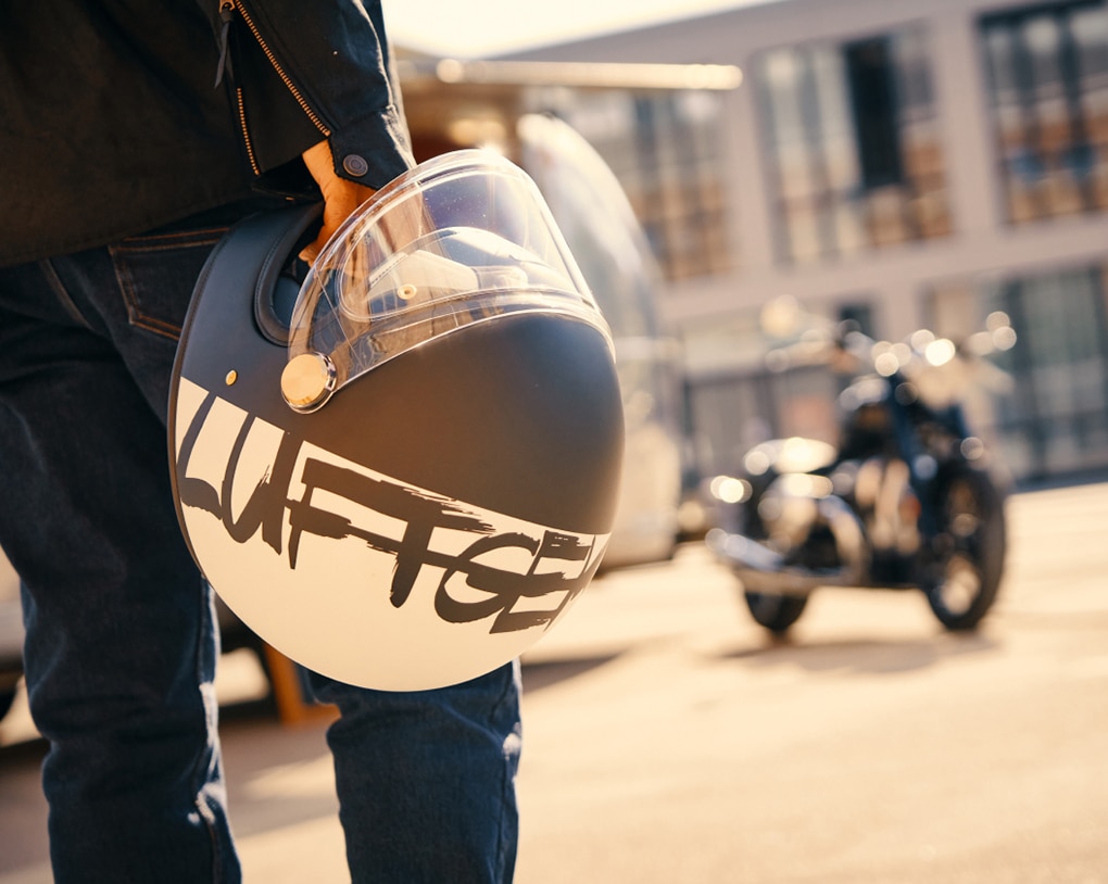 Osoba trzymająca kask motocyklowy